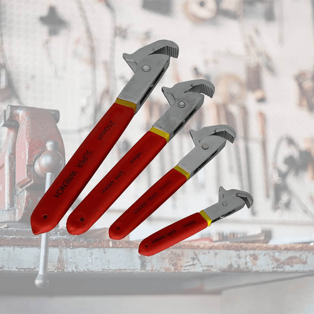 Red-handled adjustable wrenches on workshop table.
