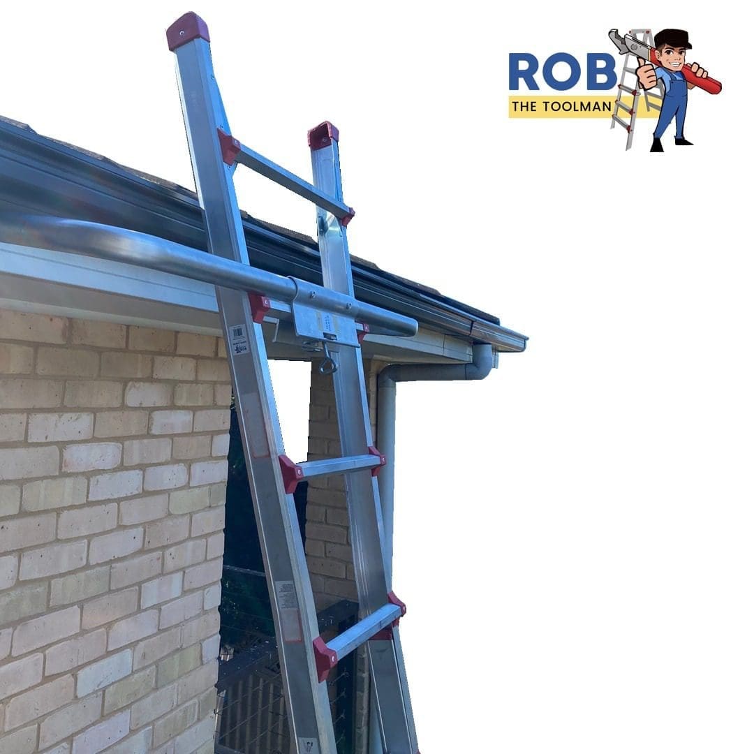 Ladder leaning against house under gutter.